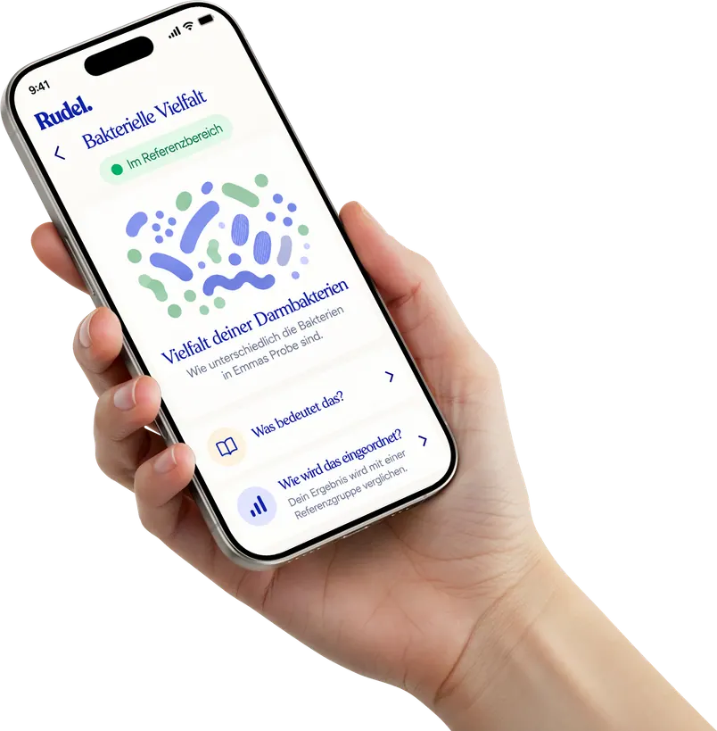 A hand holding a phone showing the dog's gut bacteria report in the Rudel app